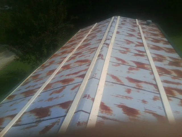 Rusted metal roof panels with new wood purlins before replacement — Storm Damage Roof Repair in Armada by Roofing Brothers