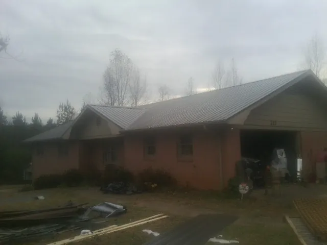 Gray metal roof on a stucco house with an attached garage in Armada